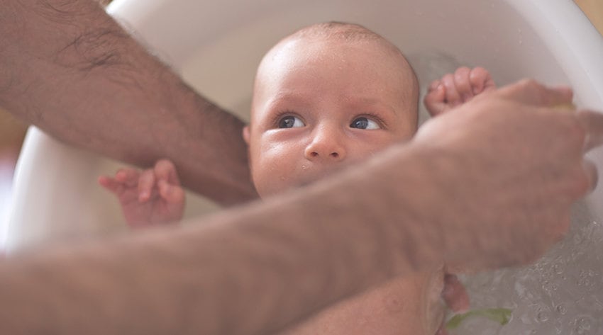 Newborn baby being bathed