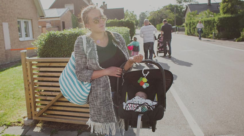 mother carrying baby in a car seat