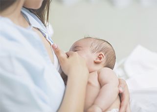 a mother breastfeeding newborn baby