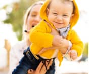 Mother holding a baby in a park