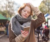 Stressed woman holding a phone with her eyes closed