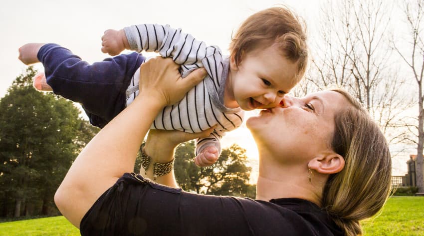 Mother kissing baby in a park