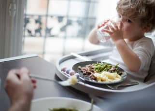 Toddler drinking water at family meal