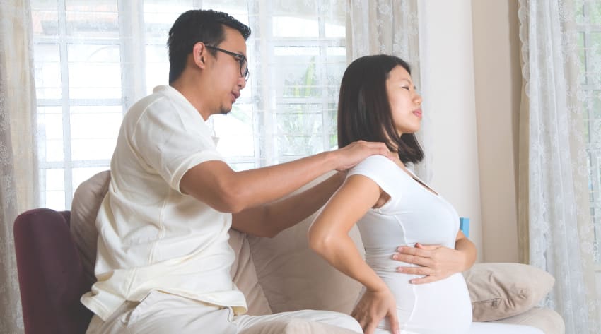 Pregnant mother receiving a shoulder massage