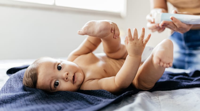 baby getting nappy changed and nappy rash cream treatment