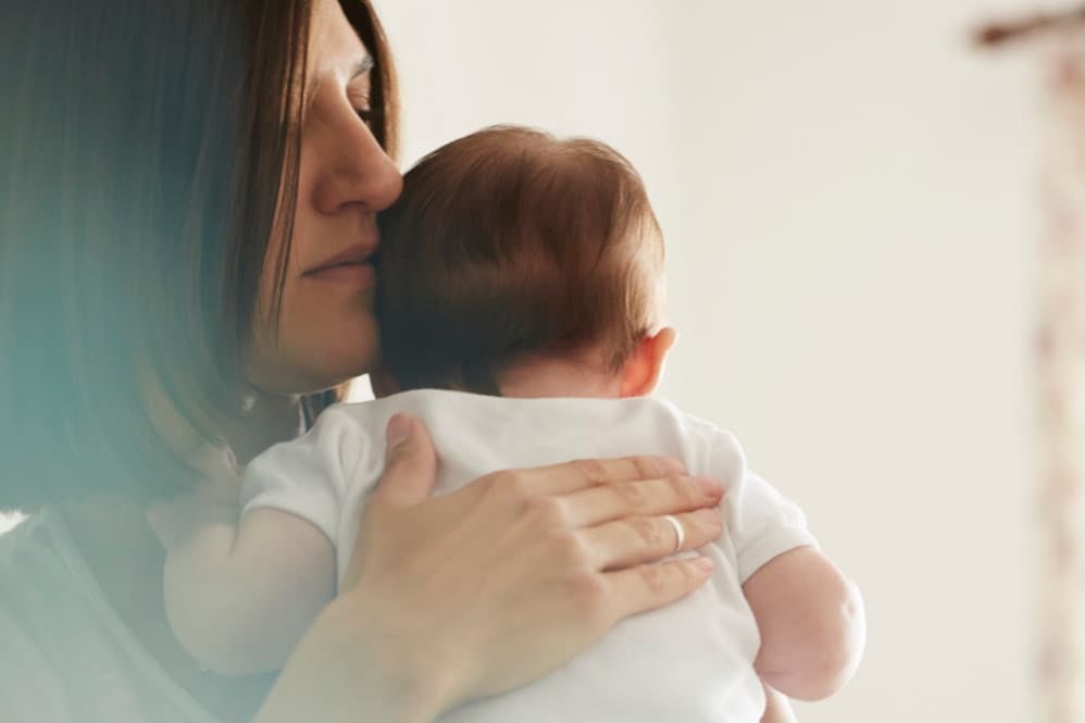 A mother holding her baby who has the hiccups