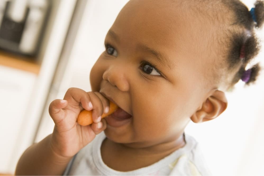 Baby eating finger food at home