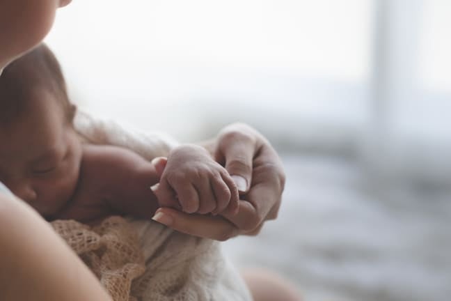 A mother soothing her baby after feeding