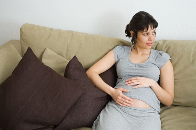 A pregnant woman holding her stomach