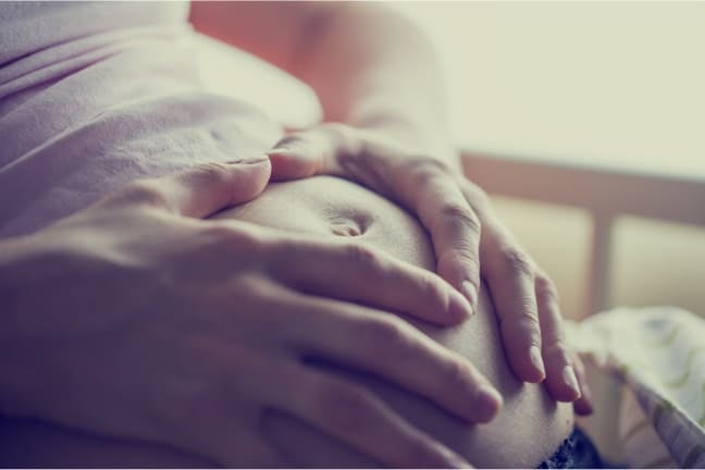 A pregnant woman holding her stomach