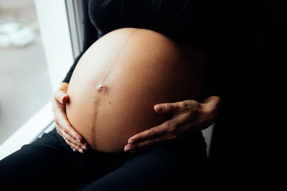 A pregnant woman holding her stomach