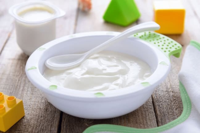 Bowl of plain yoghurt with a spoon