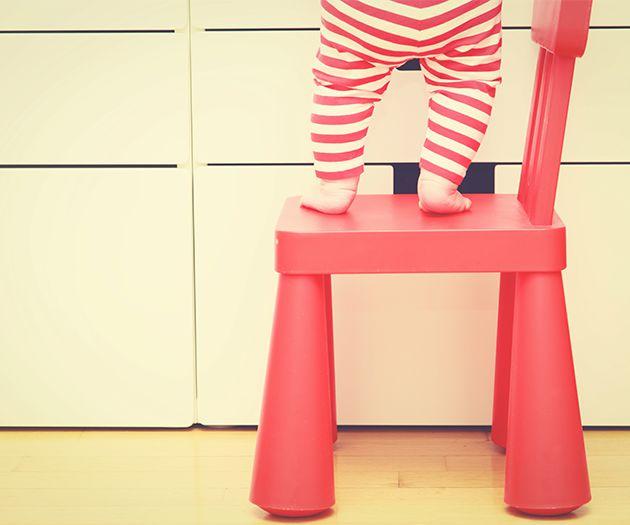 A toddler standing on a chair