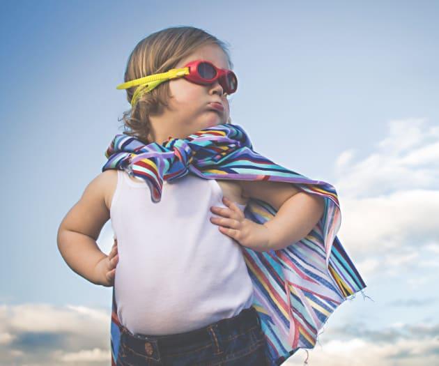 Toddler wearing cape and goggles