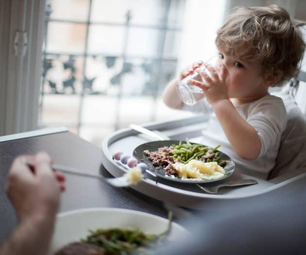 Toddler drinking water at family meal