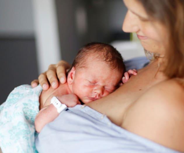 A mother holding her newborn child against her chest