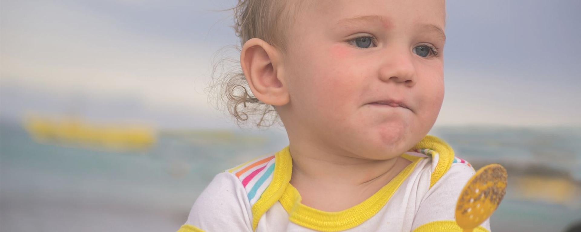 Thoughtful baby holding a spoon