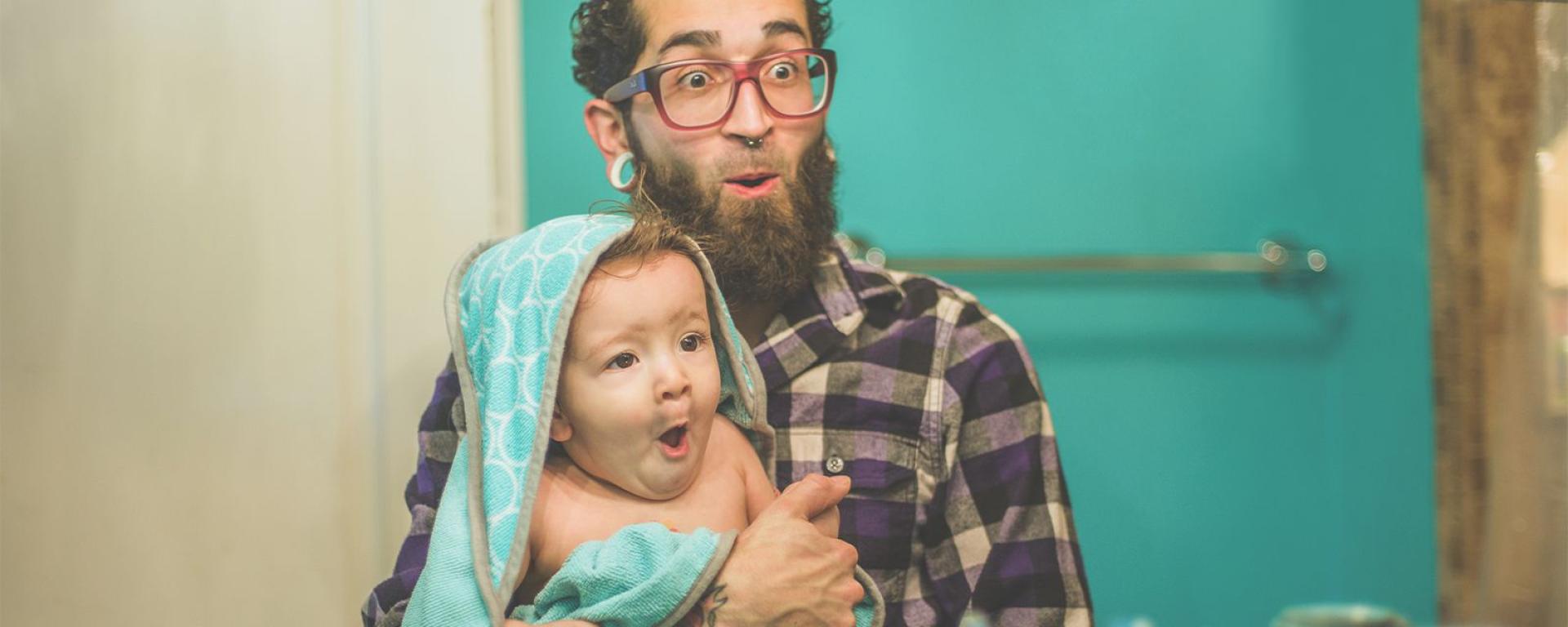 Baby and dad making gestures in front of the mirror