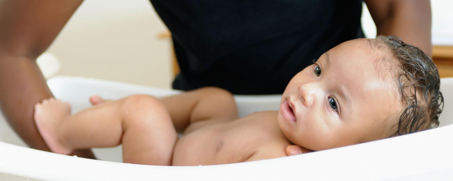 Parent bathing newborn